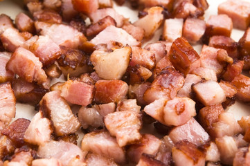 Macro photo of bacon being fried in a pan