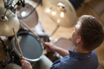 The drummer with headphones plays the drum kit