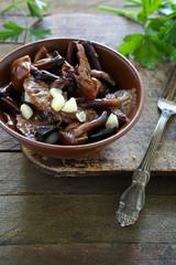 fried wild mushrooms with garlic in a ceramic bowl