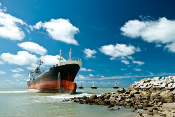 Cargo ship run aground on rocky shore © jirapong
