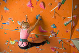 girl is engaged in rock climbing on climbing gym