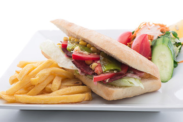 ausage sandwich with salad and french fries on the side