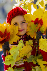 Naklejka na ściany i meble Autumn fun - lovely girl playing in autumn park