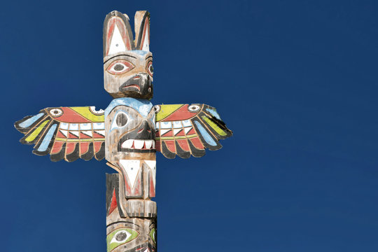 A totem wood pole in the blue background