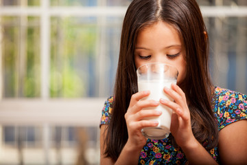 Pretty little girl drinking milk