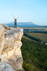Obraz premium Smiling young woman standing on the top of mountain