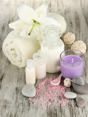 Beautiful spa setting with lily on wooden table close-up