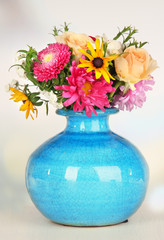 Beautiful bouquet of bright flowers in color vase,