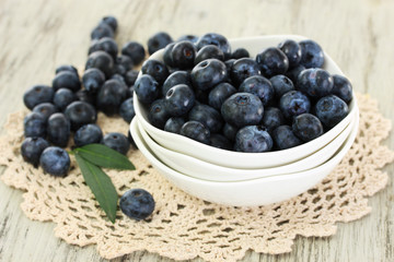 Blueberries in plates on napkin on wooden background