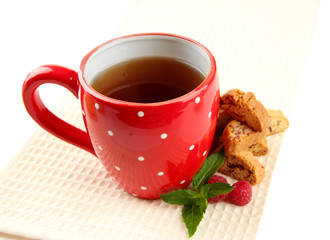 Cup of tea with cookies and raspberries isolated on white