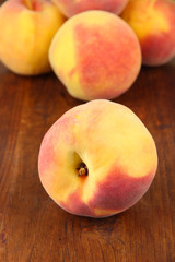 Ripe sweet peaches, on wooden background