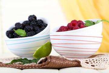 Raspberries and blackberry in small bowls