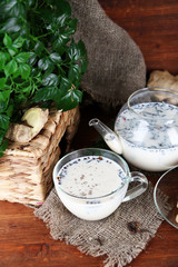 Teapot and cup of tea with milk and spices