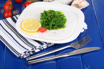 Sea kale on plate on wooden table close-up