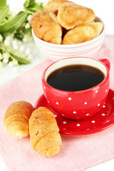 Tasty croissants and cup of coffee close-up