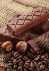 Delicious chocolate bars with nuts and coffee beans