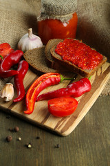 Composition with salsa sauce in glass jar,, red hot chili