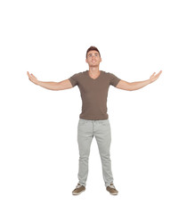Naklejka premium Casual young man looking up with arms extended