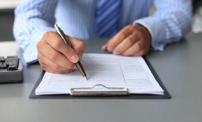 Businessman sitting at office desk signing a contract