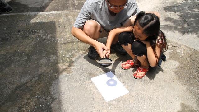 Father and daughter scientific experiments. Use a magnifying gla