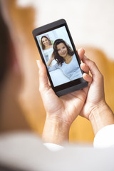 Closeup of a female hand holding a smartphone during a skype vid
