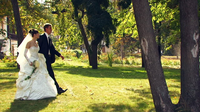 Bride and groom on a walk in a park