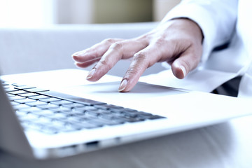 Female hands typing on a laptop trackpad