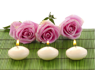 Fototapeta na wymiar Set of row rose and row candle on green mat