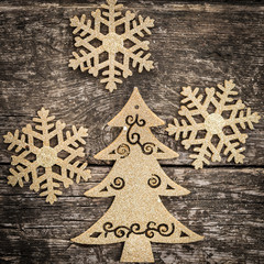 Gold Christmas tree decorations on grunge wood