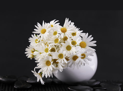 bouquet of daisies flowers in bowl with zen stones