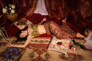 Crime scene imitation: lifeless woman in oriental costume lying