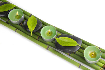 stones with fresh leaf and candle on bamboo grove