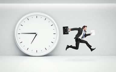 large wall clock and running businessman