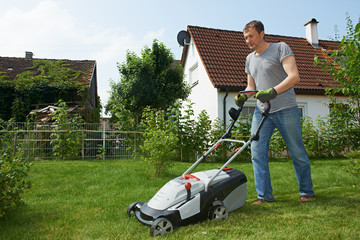 man mowing lawn in backyard