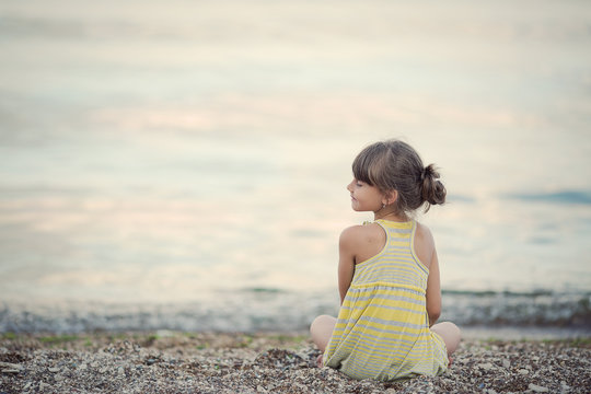 Little Girl Meditating On The Beach