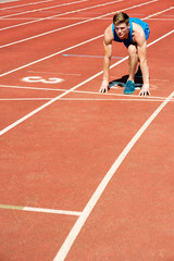 Athletic man on track, all set for race.