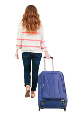 back view of walking  woman  with suitcase.