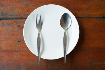 Blank dish, spoon and fork on wood table