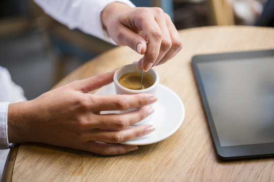 Woman drinking espresso in cafe, tablet pc