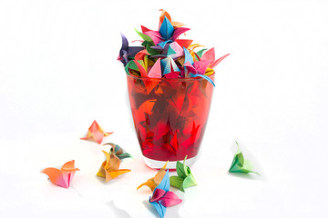 Obraz premium Red glass and flowers paper on a white background