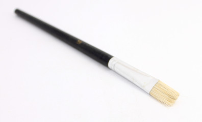 Fototapeta premium Wooden paint brush over white background