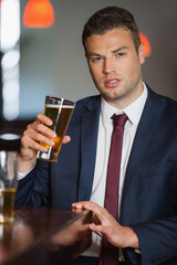 Handsome businessman having a pint