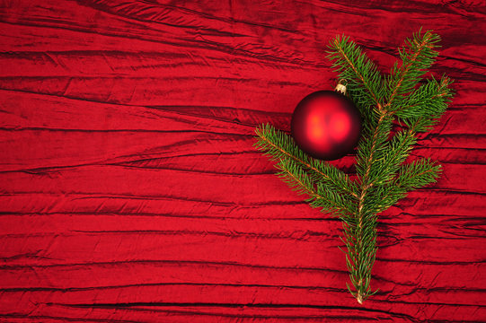 rote Christbaumkugel mit Tannenzweig