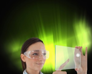 Brunette doctor in protective glasses holding virtual screen