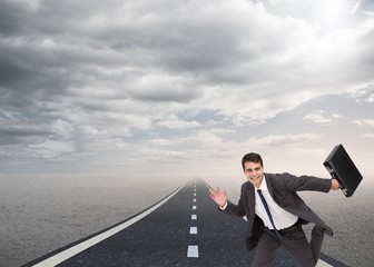 Happy businessman holding a briefcase and running