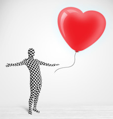 Fototapeta premium Cute guy in morpsuit body suit looking at a balloon shaped heart