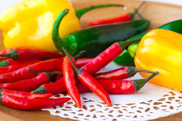 Assorted chili peppers on the wooden plate