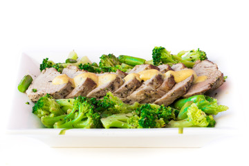 Baked, sliced fillet of pork with green vegetables, broccoli