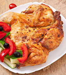 small grilled chicken with vegetables on a white dish
