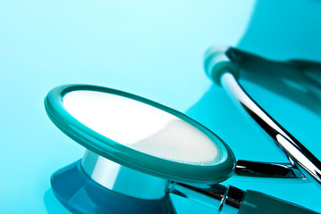 Stethoscope on blue, reflective background
